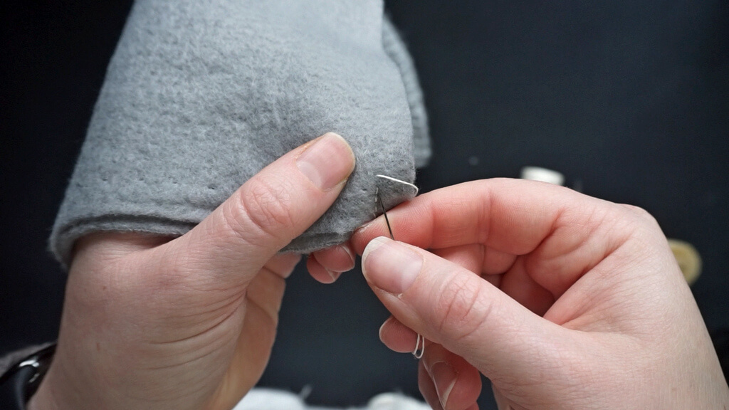 How to line a crochet beanie with fleece 6 How ho make a back stitch. Inserting the needle behind the exit point.