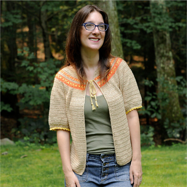 10+ Crochet round yoke sweaters and tops 2 Open front cardigan with elbow-length sleeves and banded rows in the round yoke, over which embroidery in contrasting yarn is visible.