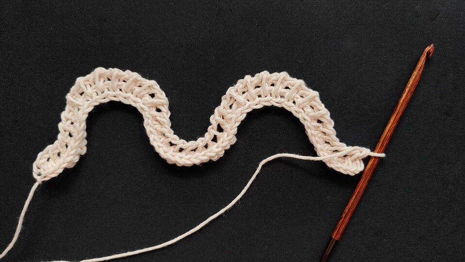 Feather and fan Tunisian crochet pattern for a washcloth 4 First and second rows of the feather and fan Tunisian crochet pattern, with the first being a regular foundation row and the second giving a wavy shape to the fabric.