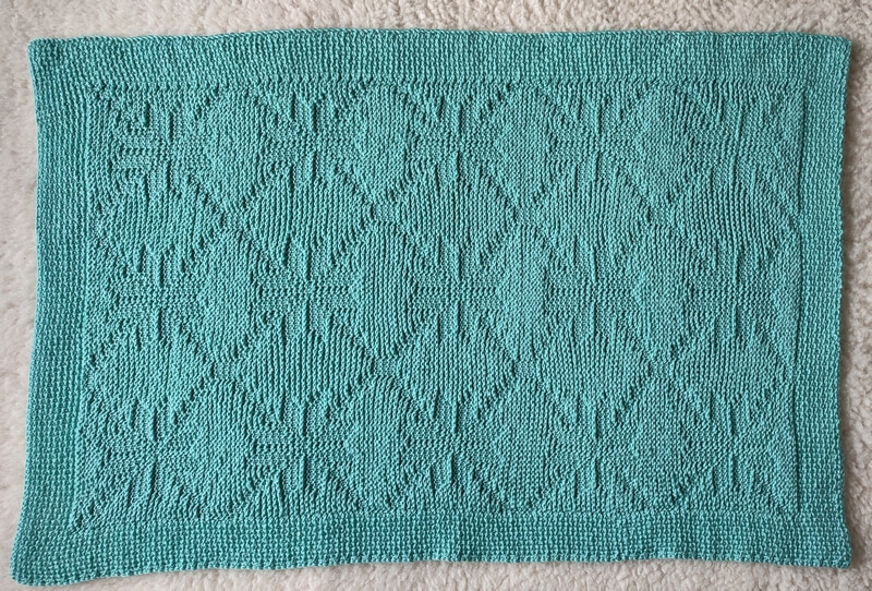 Nordic star Tunisian crochet baby blanket pattern 9 Back side of Nordic star Tunisian crochet baby blanket, showing a fainter stitch pattern than the front side.