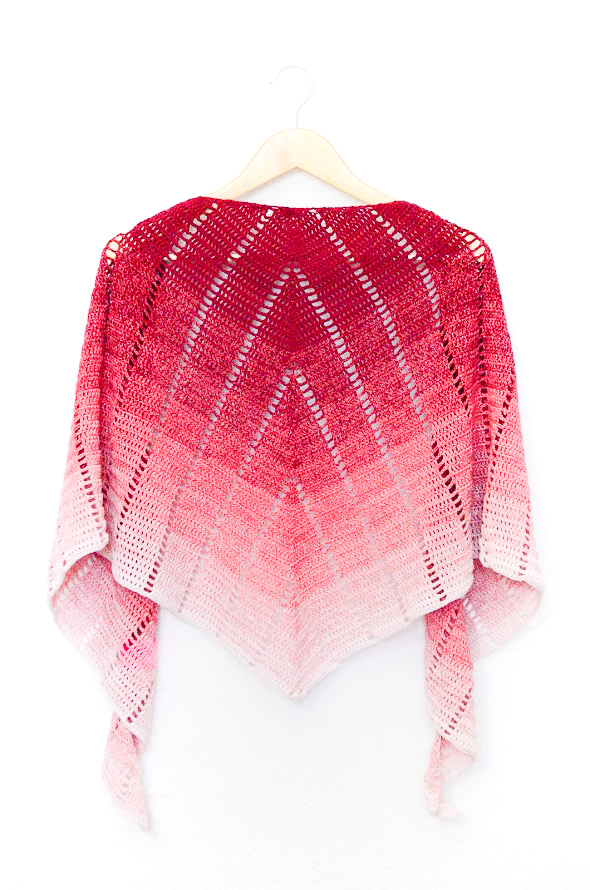 Raspberry croissant shawl that uses extended double crochet stitches at the beginning and end of each row