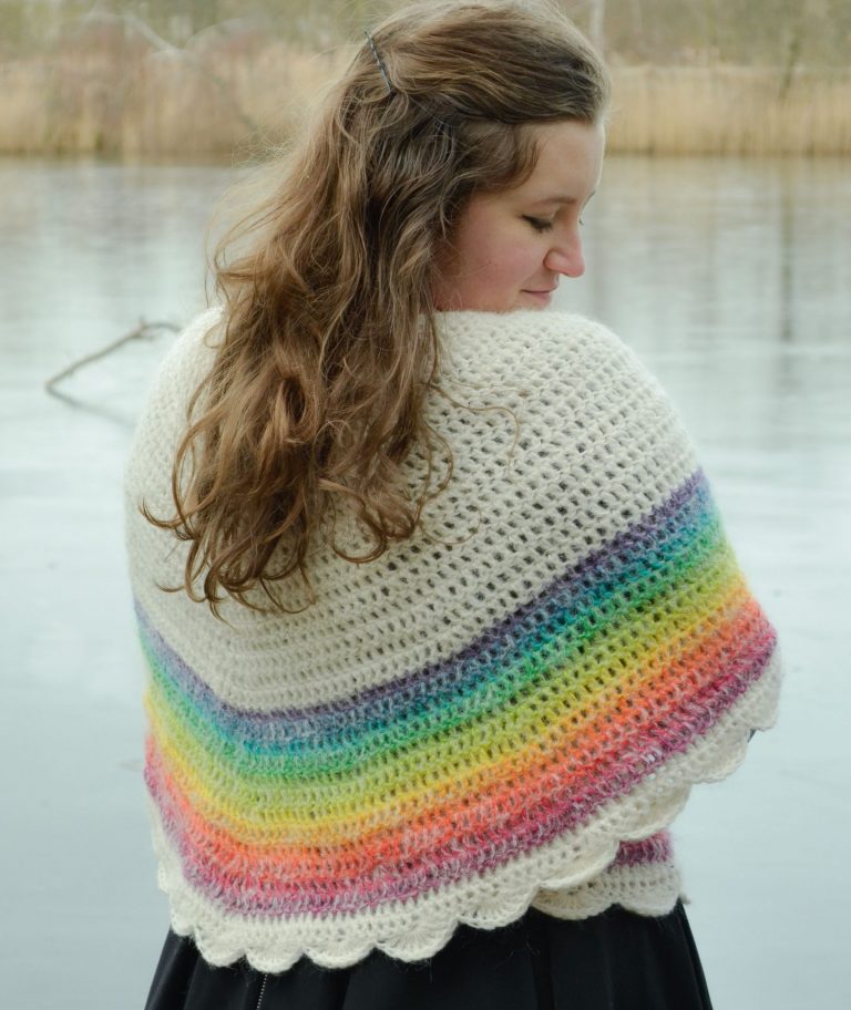 Rainbow crochet shawl worn around the shoulders and tied at the back, showing off the beautiful colors