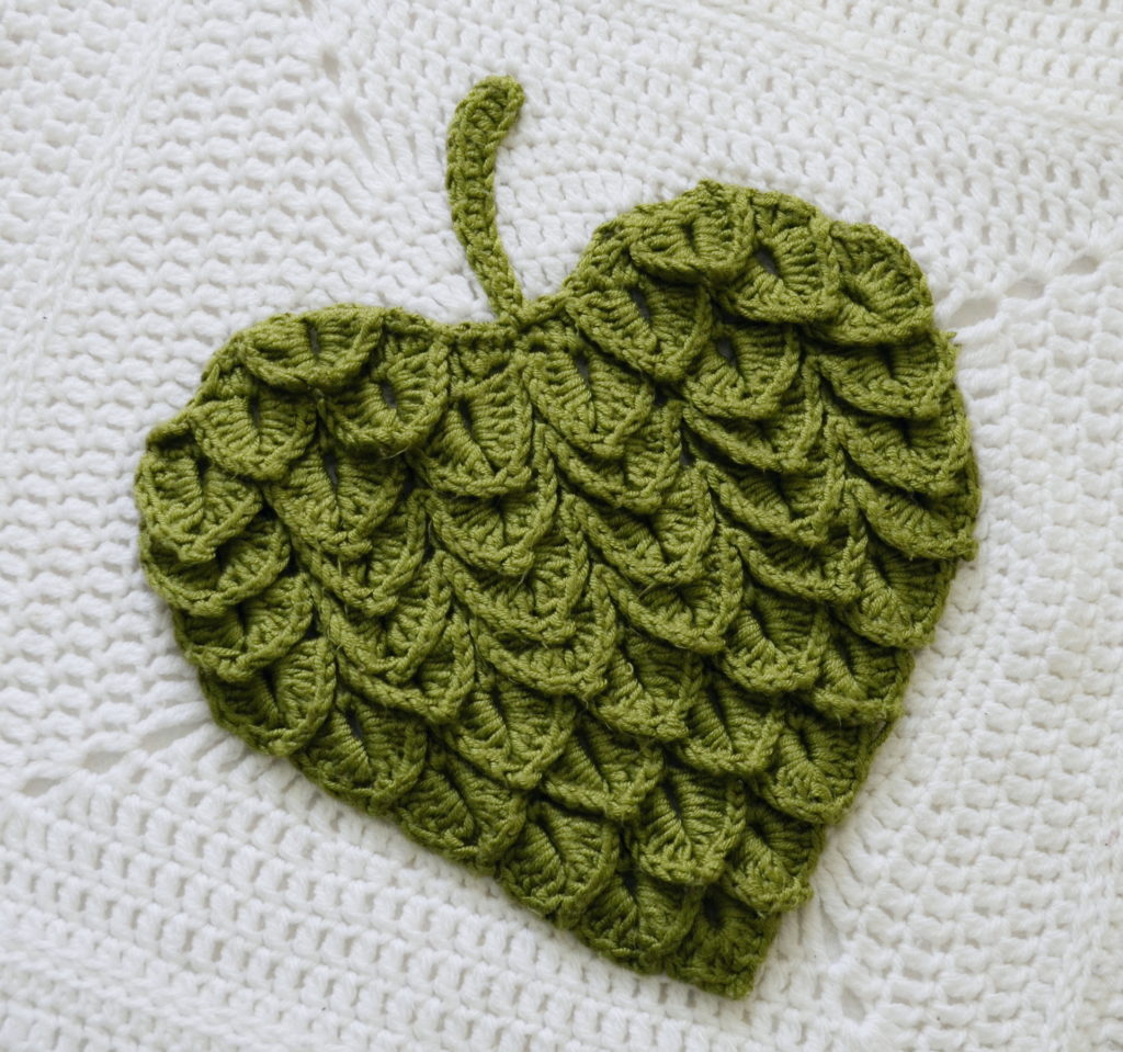 Crocodile stitch leaf on a white background made up of a crochet square