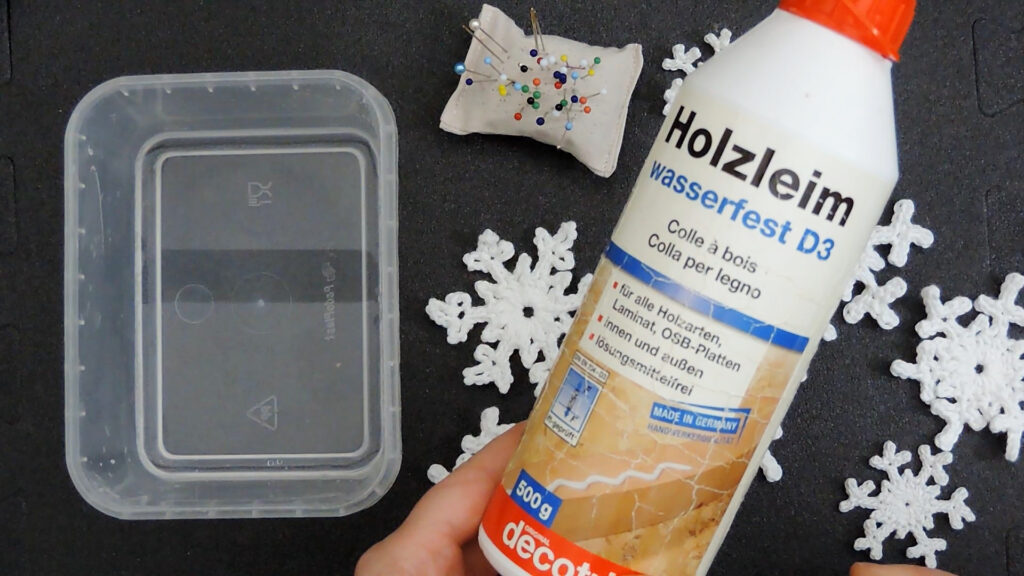 PVA glue for wood, a container with water, a pin cushion and snowflakes for stiffening
