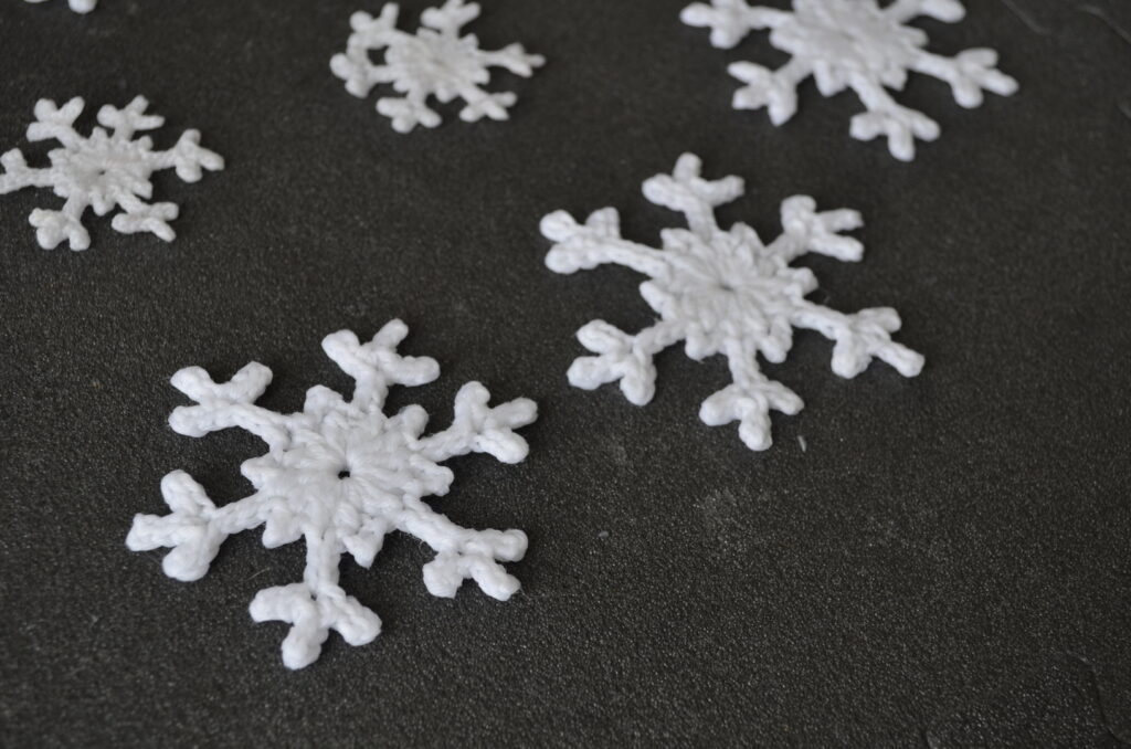 Multiple snowflakes covered in starch, laid out to dry