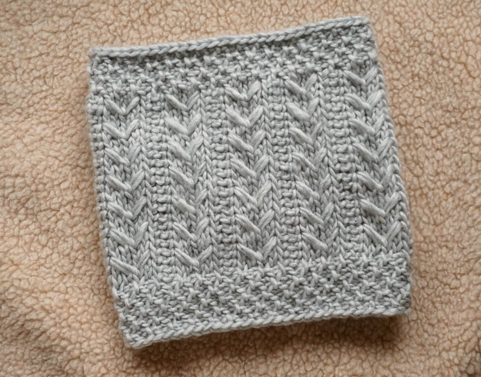 A novel Tunisian crochet stitch pattern used to create textured on the outside of this gray cowl made with roving-style chunky wool yarn
