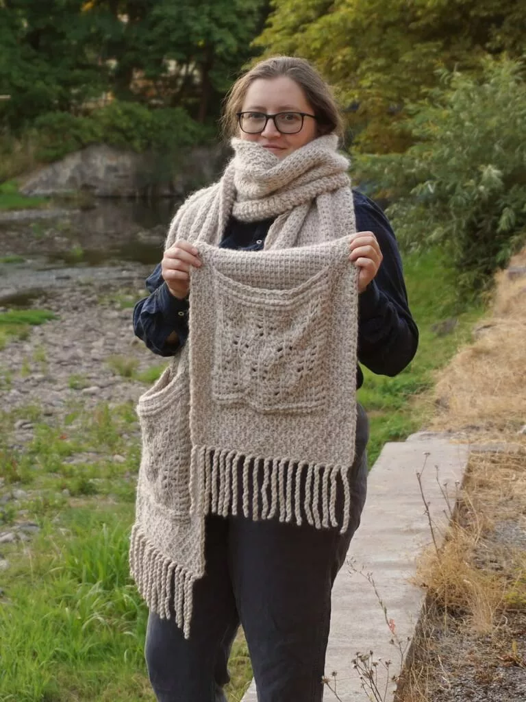 Awesome Tunisian crochet resources 16 Tunisian crochet pocket shawl being worn as scarf, with the pocket and fringe in front, showing the detailed lacy stitches on the pocket.