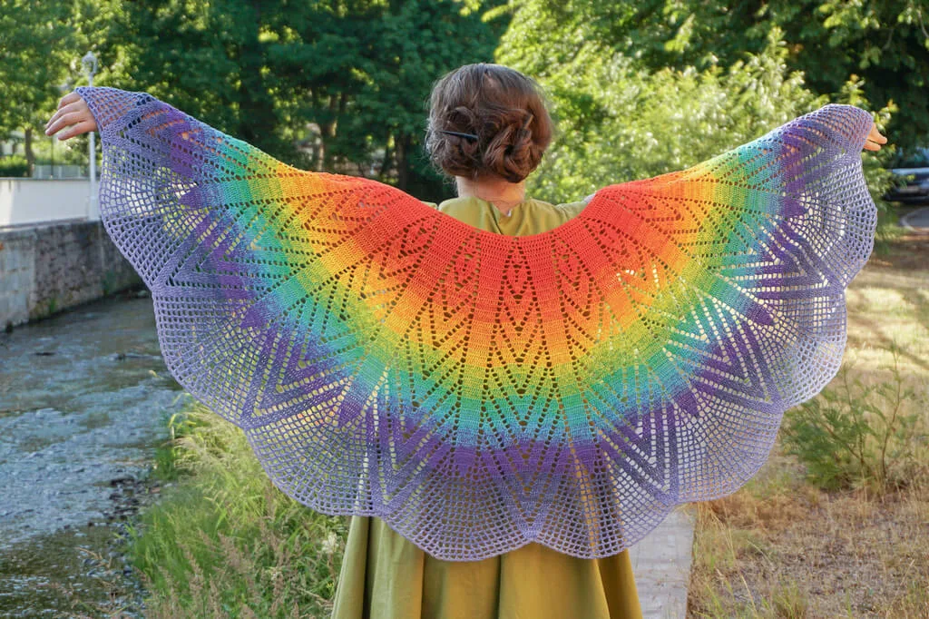 Full view of the capelet with all the wedges radiating from the neckline, with the wavy lace edge allowing the light to pass through.