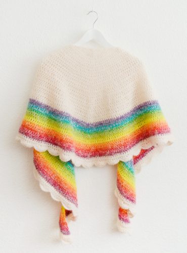 Crocheted rainbow shawl on hanger